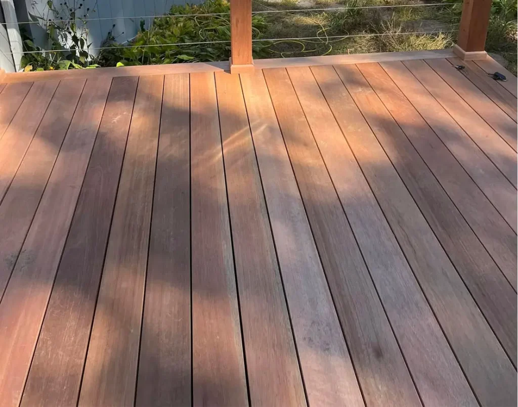 A wooden deck outside in a residential backyard.